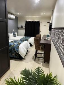 a hotel room with two beds and a desk in it at Matasawa Resort - Wailoaloa, Nadi in Nadi