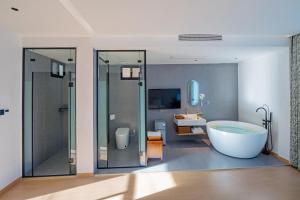 a bathroom with a tub and a shower and a sink at Blue Sea Hotel in Dali +59 photos