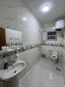 a white bathroom with a sink and a toilet at Gamandy Hostel in Luxor