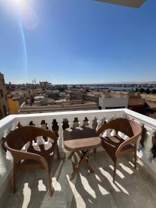 a balcony with chairs and a view of a city at Gamandy Hostel in Luxor