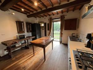 a kitchen with a table in the middle of it at Rustico Restaurato Sulle Colline Di Arezzo in San Polo