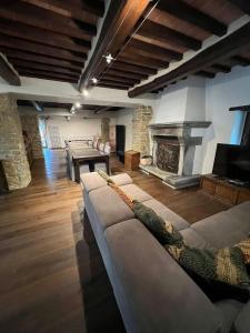 a living room with a couch and a fireplace at Rustico Restaurato Sulle Colline Di Arezzo in San Polo