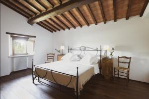 a bedroom with a bed and two chairs at Rustico Restaurato Sulle Colline Di Arezzo in San Polo