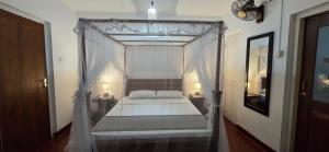 阿努拉德普勒Nature's Touch Villa的一间卧室，里面有一张带帷幔的床