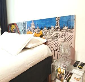 a bedroom with a bed with a painting on the wall at Studio centre historique derrière rue d'Italie - Climatisé in Aix-en-Provence +6 photos