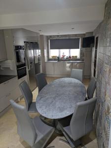 a kitchen with a table and chairs in a kitchen at Large Central Lodge Near Heathrow Airport & London with Parking in Langley Station