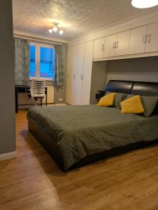 a bedroom with a large bed with yellow pillows at Large Central Lodge Near Heathrow Airport & London with Parking in Langley Station