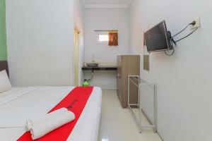 a bedroom with a bed and a tv on the wall at RedDoorz near Juanda International Airport 2 in Sidoarjo