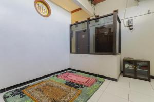 a room with a rug on the floor and a clock at RedDoorz near Juanda International Airport 2 in Sidoarjo
