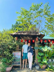 a man and woman standing in front of a kiosk at Làng Sinh Thái Ngọc Đồng - Eco Village Retreat in Thanh Sơn