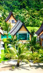 a resort with palm trees in front of a building at Juga Beach Front Villa 3B Koh Chang in Ko Chang