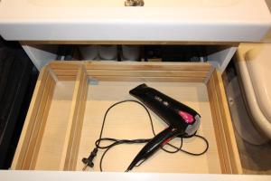 a black remote control in a wooden box under a sink at Studio centre historique derrière rue d'Italie - Climatisé in Aix-en-Provence