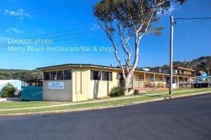 un bâtiment au bord d'une rue dans l'établissement Retro Beach Cottage - classic surf getaway, à Kioloa