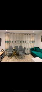 a living room with a green couch and a table at Brand new house oxford in Oxford