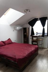 a bedroom with a red bed and a table at CASA Don Lucio in Craiova