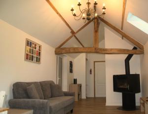 Una sala de estar con un sofá y un televisor en Honey Suckle Hideaway, en Céaucé