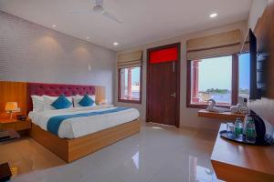 ein Schlafzimmer mit einem großen Bett und blauen Kissen in der Unterkunft The Aanandam By Agravansh in Haridwar