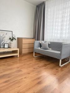 - un salon avec un canapé et du parquet dans l'établissement Imantas apartment, à Daugavpils