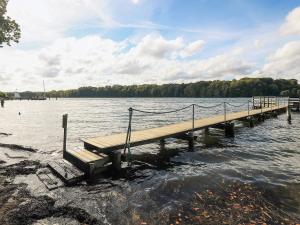 a dock on a lake with a bench in the water at Middelfart Home- nearby free waterpark access in Middelfart +36 photos