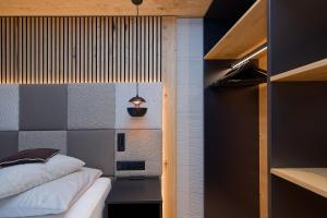 a small room with a bed and a shelf at Panorama Samnaun in Samnaun