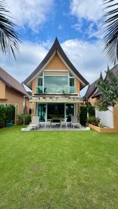 a house with a patio and grass yard at Juga Beach Front Villa 3B Koh Chang in Ko Chang