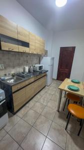 cocina con encimera, mesa y nevera en Sweet Inn Apartment, en Piteşti