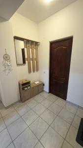 a room with a wooden door and a tiled floor at Sweet Inn Apartment in Piteşti +20 photos
