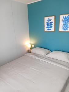 a bedroom with a white bed with a blue wall at Stylish Urban Escape 1Bed Apt T2-822 in Ban Klang