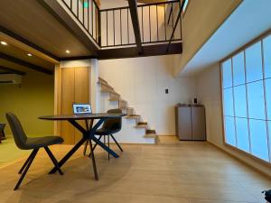 an office with a table and chairs and stairs at Machiya inside Chomoji temple, near Gion, downtown in Shimmachidōri +8 photos