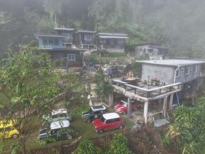 a group of cars parked in front of a house at ม่านฟ้าฮิลล์ ภูชี้ฟ้า in Ban Huai Han