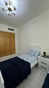 sypialnia z łóżkiem, komodą i sufitem w obiekcie Bed space in al majaz 2 w Szardży