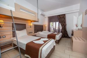 Una habitación de hotel con dos camas y una ventana. en Amalia Mare Sea View, en Nea Vrasna 152 fotos más