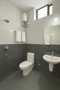 ein Badezimmer mit Toilette und Waschbecken in der Unterkunft Hotel Shiva Classic, Calangute Beach Goa in Calangute + 16 Fotos