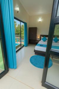 ein Schlafzimmer mit einem Bett und Blick auf einen Pool in der Unterkunft Hotel Shiva Classic, Calangute Beach Goa in Calangute