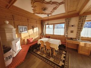 een eetkamer met een tafel en een open haard bij Chalet Milandora in La Villa