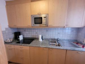 een keuken met een spoelbak en een magnetron bij Chalet Milandora in La Villa +25 foto's