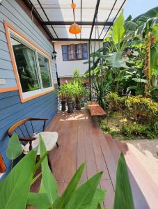 a patio with plants and a blue house at We Home Guesthouse in Ban Pa Bong