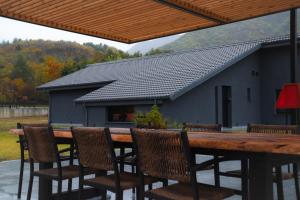 una mesa de madera y sillas con una casa en el fondo en λαλώ, en Órma