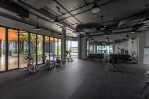 a gym with bikes parked in a room with windows at Bellevue Lagoon Premium Apart Hotel by TropicLook in Laguna Phuket