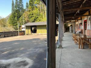 a porch of a building with a table and benches at 茄苳仔23民宿 in Zhuqi