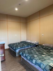 two beds in a room with two beds sidx sidx sidx at 茄苳仔23民宿 in Zhuqi