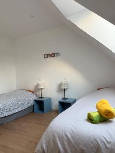 - une chambre avec 2 lits et des serviettes jaunes dans l'établissement Ty Cocon - havre de paix avec jacuzzi, à Rochefort-en-Terre