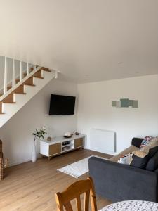 un salon avec un canapé et une télévision dans l'établissement Ty Cocon - havre de paix avec jacuzzi, à Rochefort-en-Terre