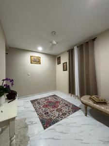 een woonkamer met een tapijt op de vloer bij Nora Guest House in Kerteh