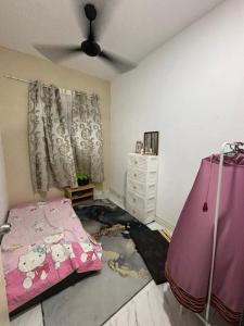een slaapkamer met een bed en een plafondventilator bij Nora Guest House in Kerteh