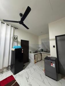 een woonkamer met een plafondventilator en een keuken bij Nora Guest House in Kerteh
