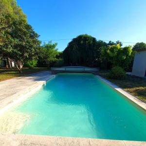 een groot blauw zwembad in een tuin bij L'Escandihado in Saint-Étienne-du-Grès