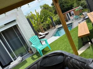 a blue chair sitting on a lawn next to a swimming pool at Maison cocooning , avec double jacuzzi et piscine in La Machine