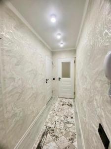 a hallway with a white door and a wall at Appartament Shymkent in Shymkent