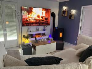 a living room with a fire in the wall at Maison cocooning , avec double jacuzzi et piscine in La Machine
